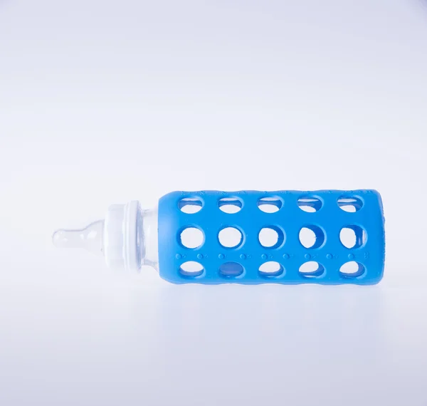 Baby glass bottle or blue baby bottle on background. — Stock Photo, Image