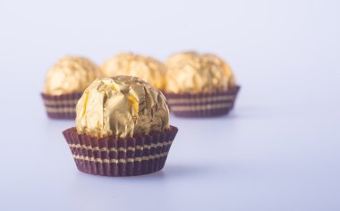 Bir altın folyo kağıt arka plan üzerinde çikolata topu.