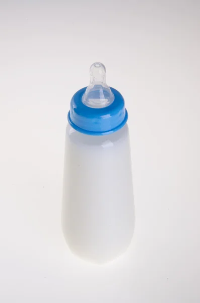 Bottiglia bambino con latte sullo sfondo — Foto Stock