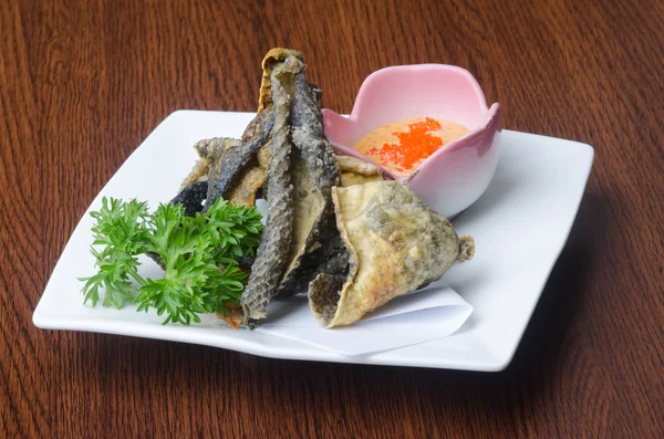 Japanse keuken. gebakken vis huid op de achtergrond — Stockfoto