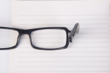 gözlükleri. Gözlükleri ile arka planda kitap