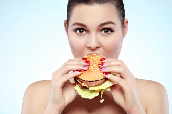 Funny girl eating vegetables on light background — Stock Photo, Image