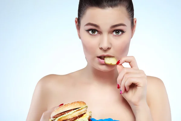 Fille drôle manger des légumes sur fond clair — Photo