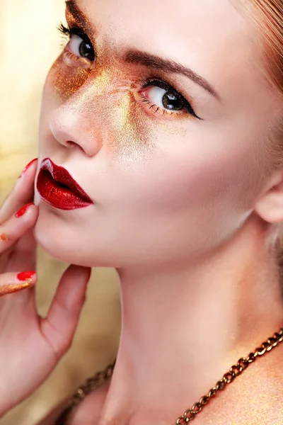 Closeup portrait of sexy  young woman with beautiful blue eyes and red lips on gold  background — Stock Photo, Image