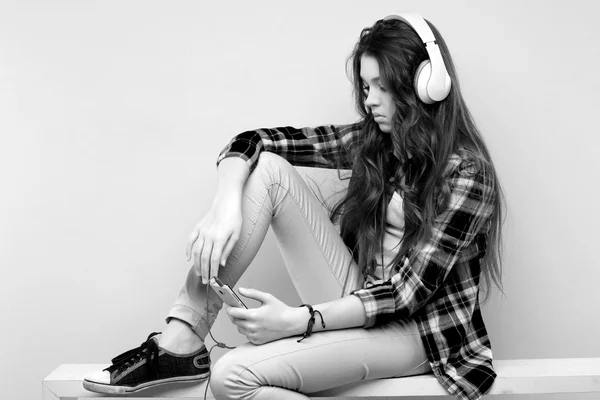 Hermosa chica de pelo largo joven con auriculares y teléfono , — Foto de Stock