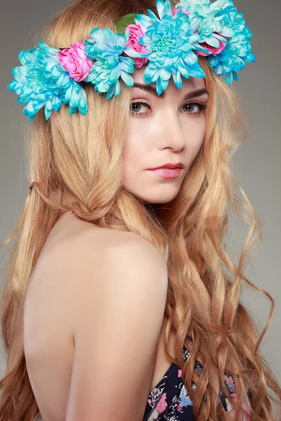 Όμορφη κοπέλα, απομονωμένη σε ένα φως - γκρι φόντο με χρωματιστοί λουλούδια σε τρίχες, συναισθήματα, καλλυντικά — Φωτογραφία Αρχείου