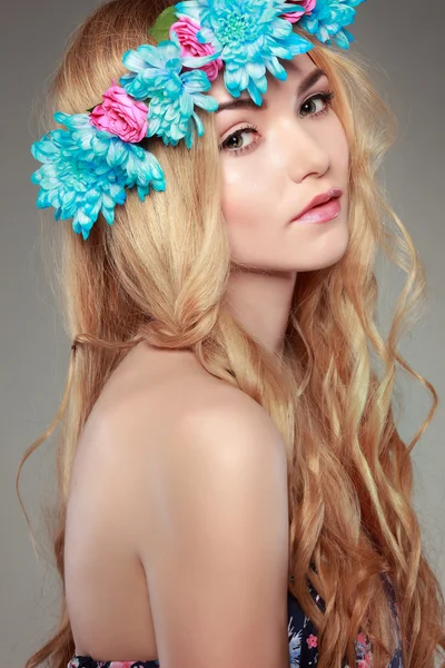Красива дівчина, ізольована на світлому - сірому тлі з різнокольоровими квітами у волоссі, емоціях, косметиці — стокове фото