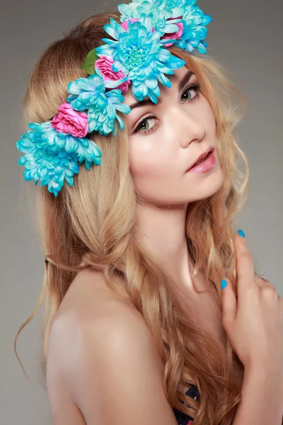 Schönes Mädchen, isoliert auf einem hellgrauen Hintergrund mit bunten Blumen in Haaren, Emotionen, Kosmetik — Stockfoto