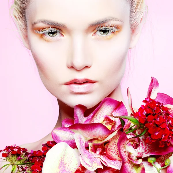 Vacker flicka med varicoloured blommor — Stockfoto