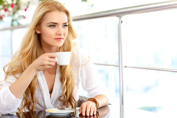 Mooi blond meisje, zittend in een café — Stockfoto