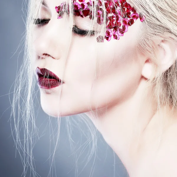 Vacker flicka med varicoloured blommor Stockfoto