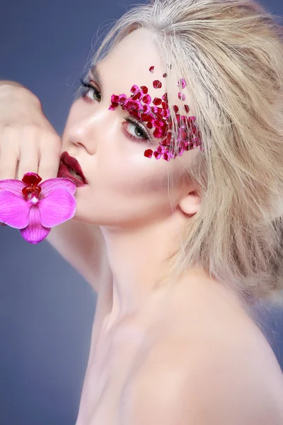 Vacker flicka med varicoloured blommor Stockbild