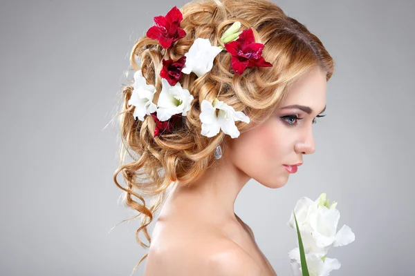 Menina bonita, isolado em uma luz - fundo cinza com flores variadas em cabelos, emoções, cosméticos — Fotografia de Stock