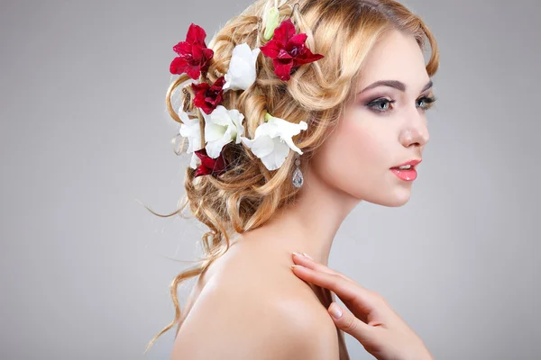 Schönes Mädchen, isoliert auf einem hellgrauen Hintergrund mit bunten Blumen in Haaren, Emotionen, Kosmetik — Stockfoto