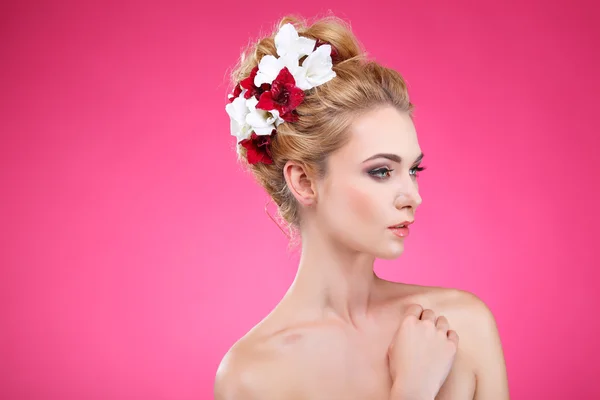 Schönes Mädchen, isoliert auf rosa Hintergrund mit bunten Blumen in Haaren, Emotionen, Kosmetik — Stockfoto