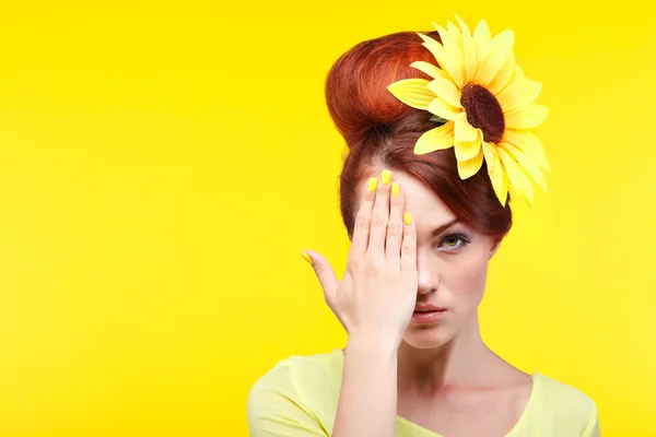 Schönes Mädchen, isoliert auf gelbem Hintergrund mit gelben Blume im Haar, Emotionen, Kosmetik — Stockfoto