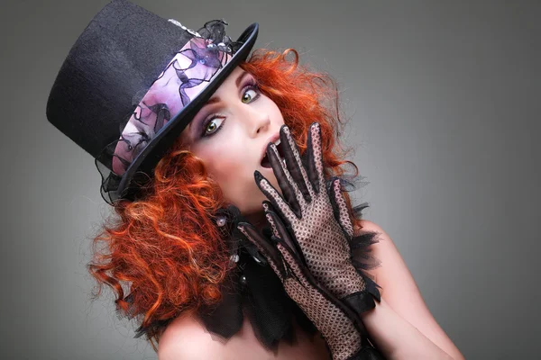 Ritratto di bella ragazza dai capelli rossi sessuale in un cappello nero su sfondo grigio. Accessori . — Foto Stock