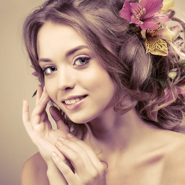 Menina bonita, isolado em uma luz - fundo cinza com flores variadas em cabelos, emoções, cosméticos — Fotografia de Stock