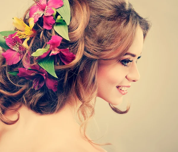 Menina bonita, isolado em uma luz - fundo cinza com flores variadas em cabelos, emoções, cosméticos — Fotografia de Stock