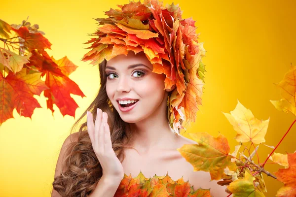 Gros plan portrait de belle jeune fille dans un chapelet de feuilles d'automne varicolores sur un fond jaune — Photo