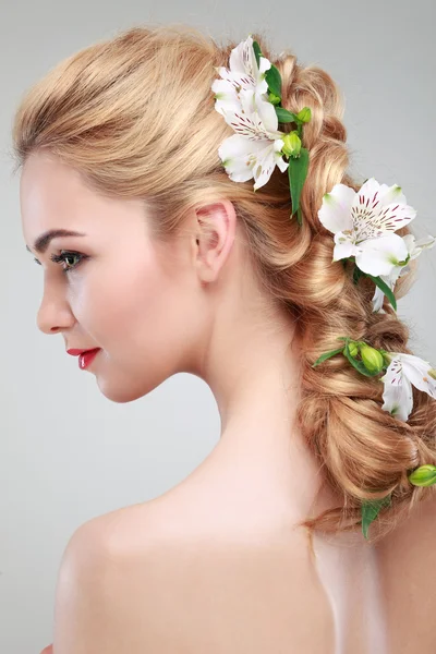 Schönes Mädchen, isoliert auf einem hellgrauen Hintergrund mit bunten Blumen in Haaren, Emotionen, Kosmetik — Stockfoto