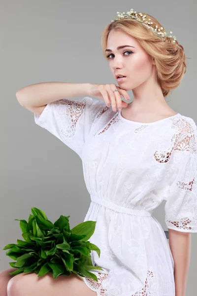 Beautiful sexual blonde  in white  clothes with the basket of flowersd on a grey background — Stock Photo, Image