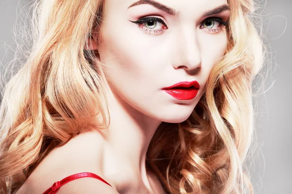 Closeup portrait of sexy  young woman with beautiful blue eyes and red lips on a grey background — Stock Photo, Image