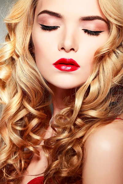 Nahaufnahme Porträt einer sexy jungen Frau mit schönen blauen Augen und roten Lippen auf grauem Hintergrund — Stockfoto