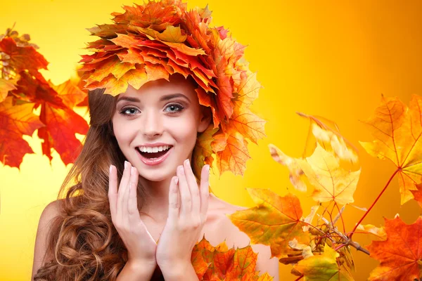 Gros plan portrait de belle jeune fille dans un chapelet de feuilles d'automne varicolores sur un fond jaune — Photo