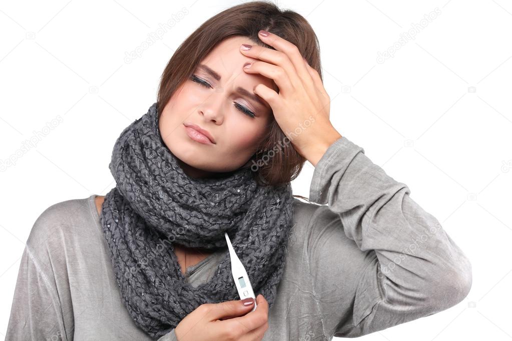 woman taking her temperature wile feeling sick and with fever, isolated on a white background