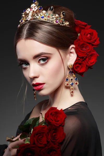 woman with crown and red roses in hairstyle