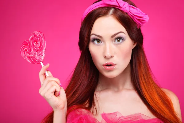 Beautiful  redheaded girl with  large candy — Stock Photo, Image