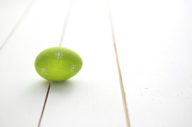 Beyaz ahşap zemin üzerinde bir yeşil Paskalya yortusu yumurta