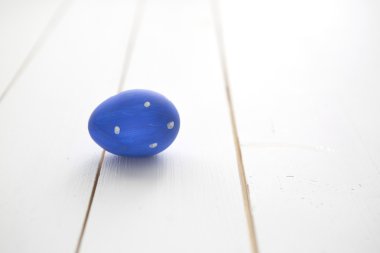 Beyaz ahşap zemin üzerinde mavi bir Paskalya yortusu yumurta