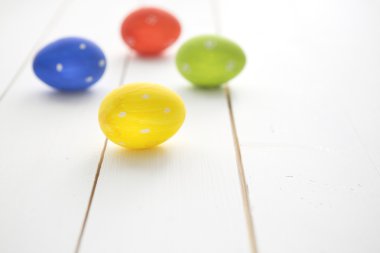 Paskalya yumurtaları bir beyaz tahta arka plan üzerinde boyalı