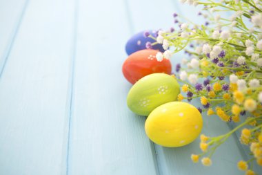 Renkli Paskalya yumurta beyaz ahşap zemin üzerine dekore edilmiştir.. 