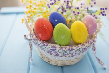 Bir ahşap tahta üzerinde Paskalya yumurtaları sepetle 