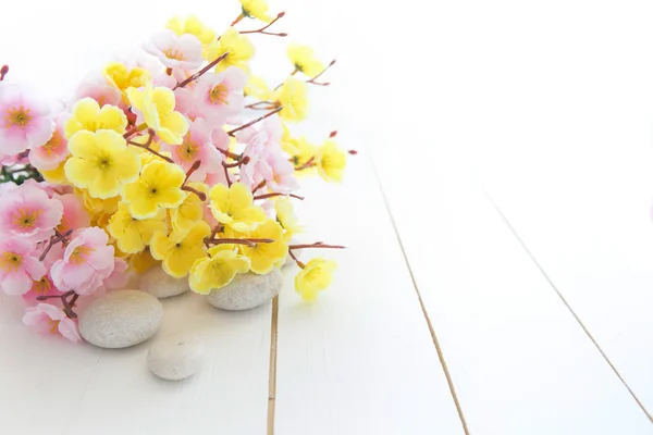 Spa stones with pink and yellow sakura flowers — Stock Photo, Image