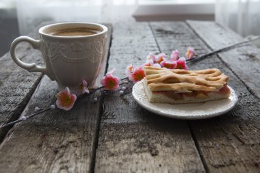 Fincan kahve ve pembe kiraz çiçekleri. 