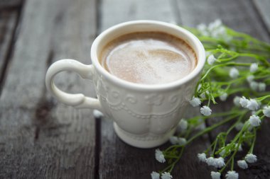 Masaya siyah kahve ve beyaz çiçek fincan