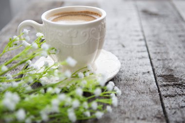 Masaya siyah kahve ve beyaz çiçek fincan