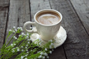 Masaya siyah kahve ve beyaz çiçek fincan