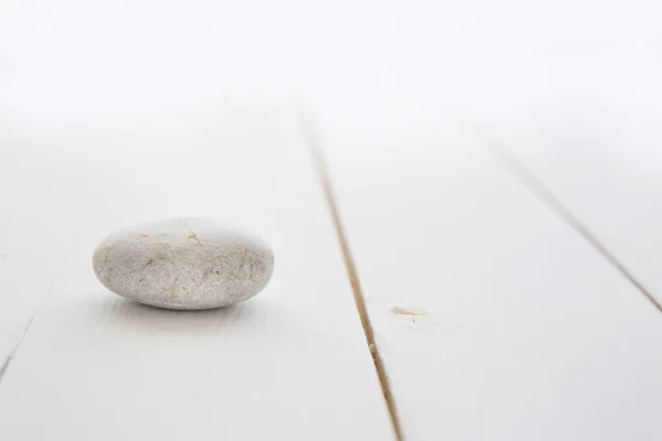 Uma pedra branca em uma mesa de madeira — Fotografia de Stock