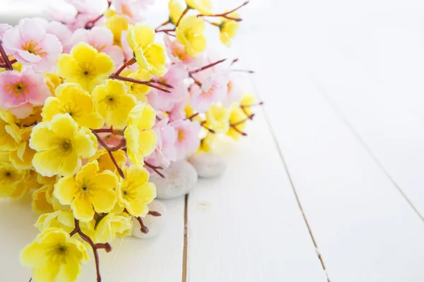 Спа камені з рожевими і жовтими квітами сакури — стокове фото