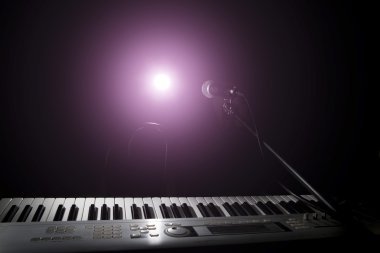 Microphone  and piano in dark background clipart