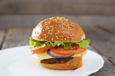 Tablo üzerinde beyaz bir tabak içinde Burger
