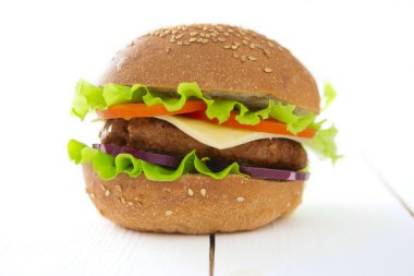 Ahşap masa üzerinde lezzetli hamburger.