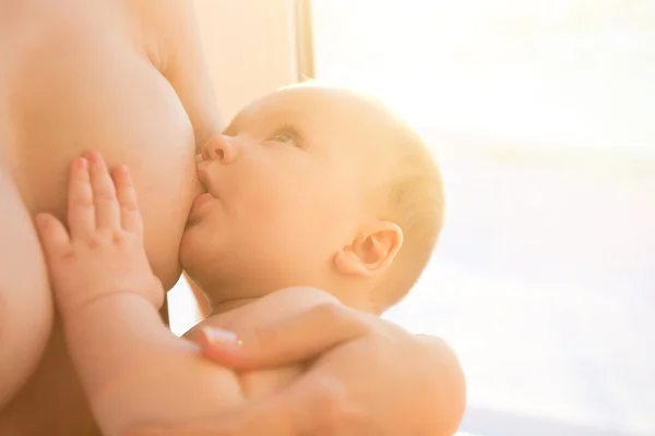 Mãe feliz amamentando seu bebê infantil — Fotografia de Stock
