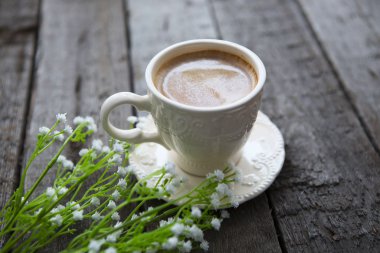 Masaya siyah kahve ve beyaz çiçek fincan