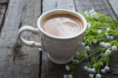 Masaya siyah kahve ve beyaz çiçek fincan